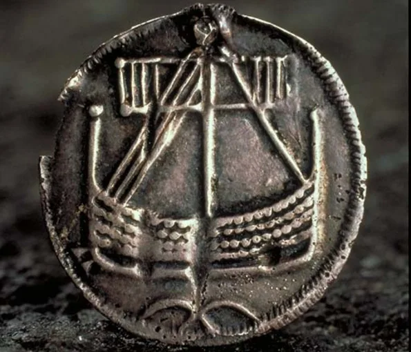 Mynt med en urkarvad båt 