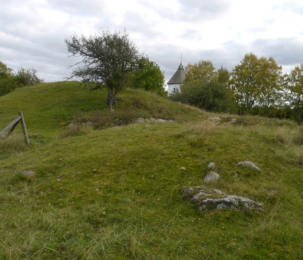 En gravhög med ett träd vid sluttningen