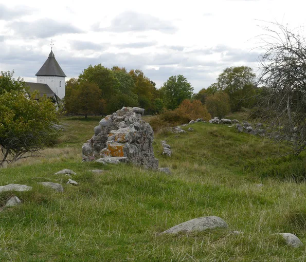 Stenrös med kyrka i bakgrunden