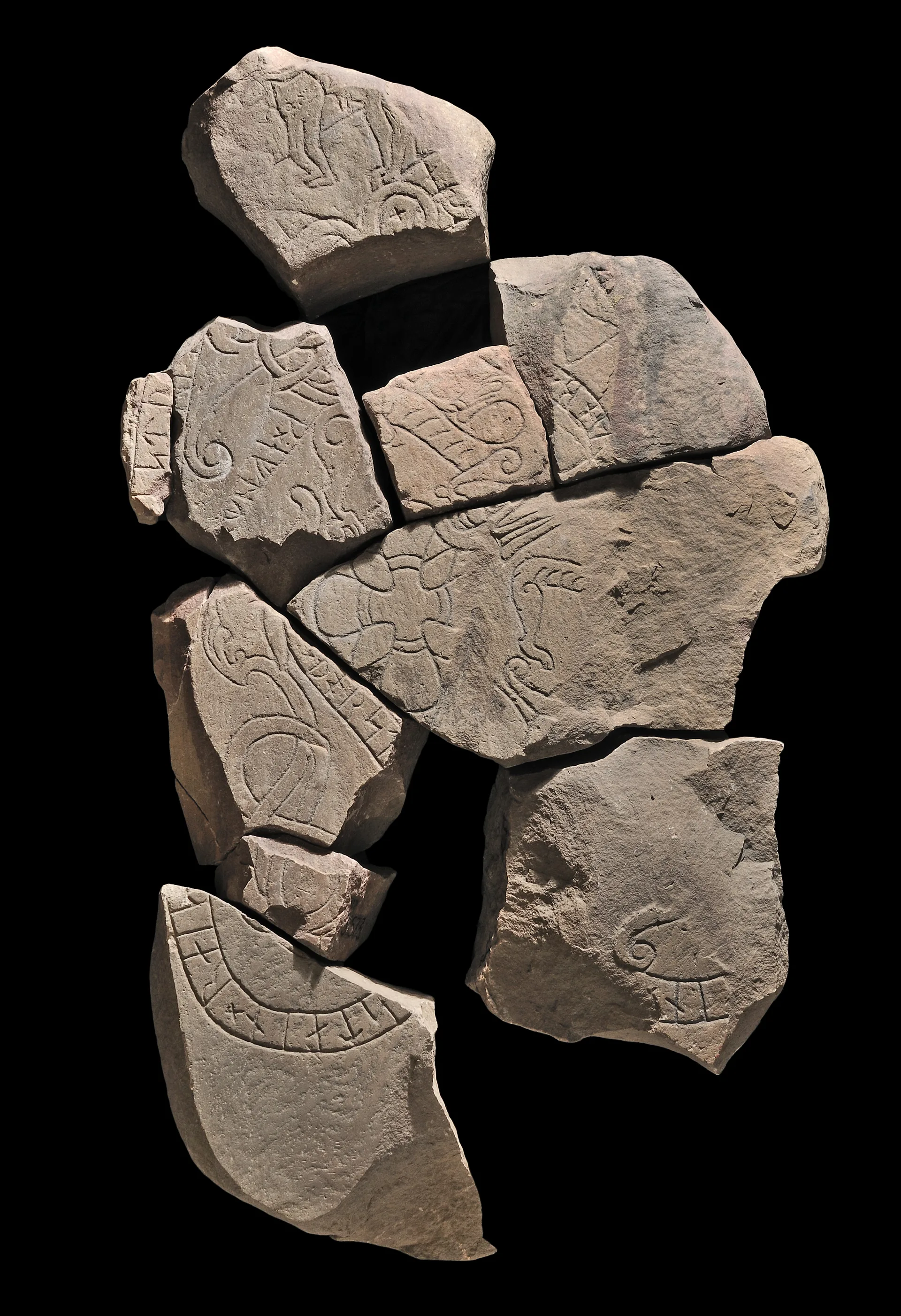 En runsten i flera delar med rinskrift på.